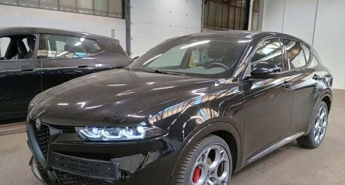 SUV sportivo nero parcheggiato al chiuso con un'elegante griglia anteriore e cerchi argentati