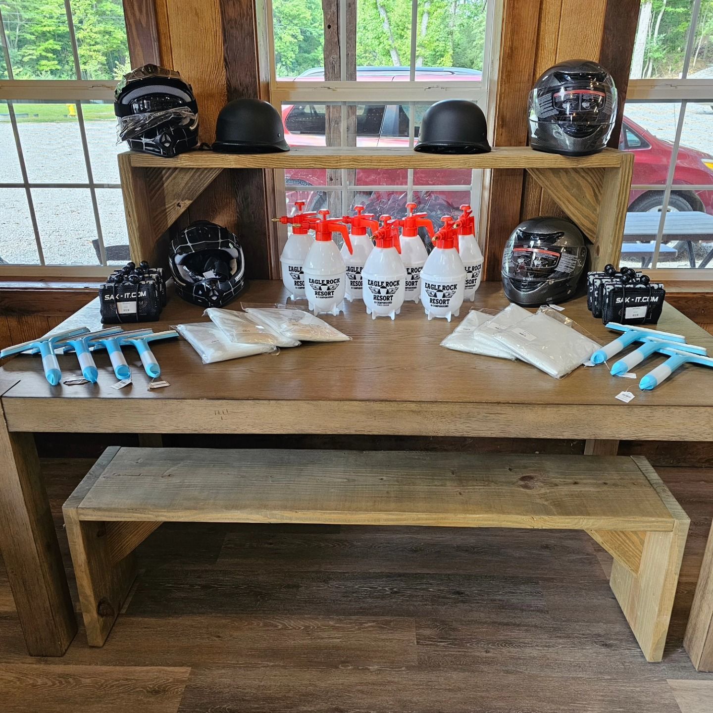 A rustic table displays helmets, bowling pins, and gloves inside a wooden cabin.