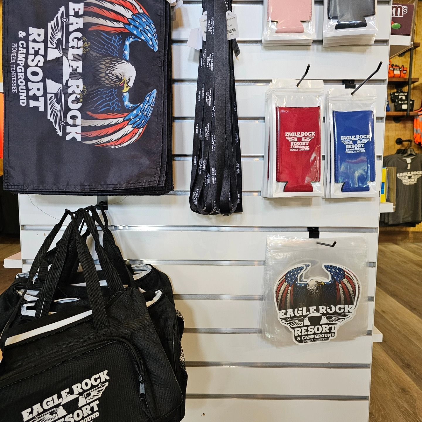 Merchandise display featuring Eagle Rock Resort logo: bags, towels, koozies, and sticker.