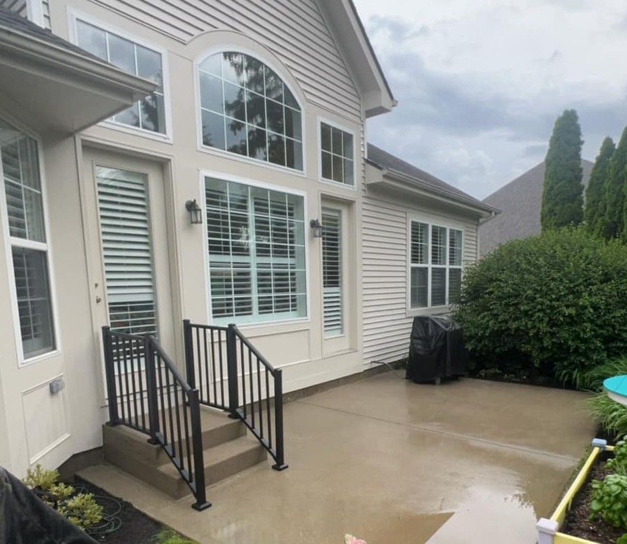 A house with a patio and stairs in front of it.