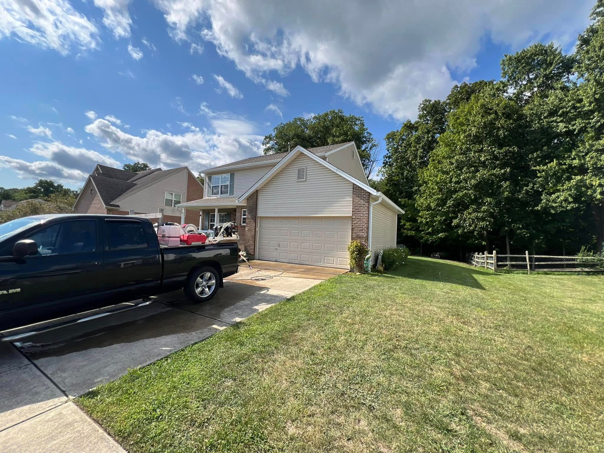 A black truck is parked in front of a house.