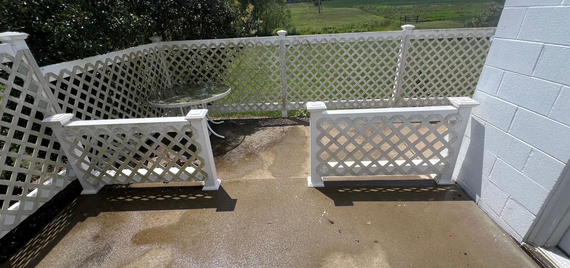 A white lattice fence surrounds a concrete patio