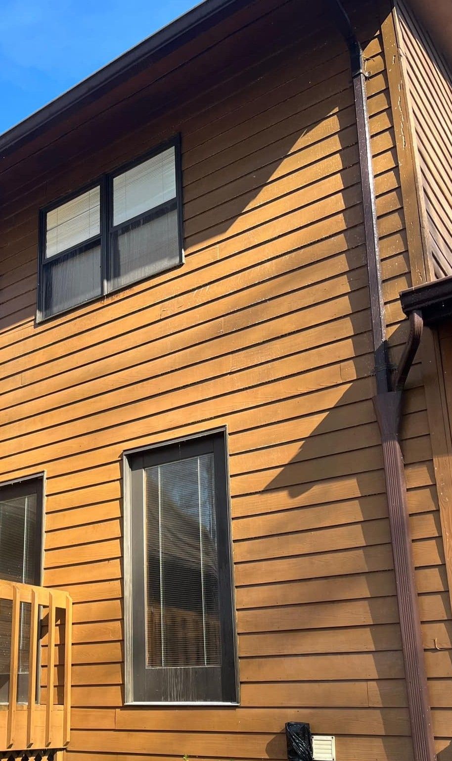 A house with a wooden siding and black windows