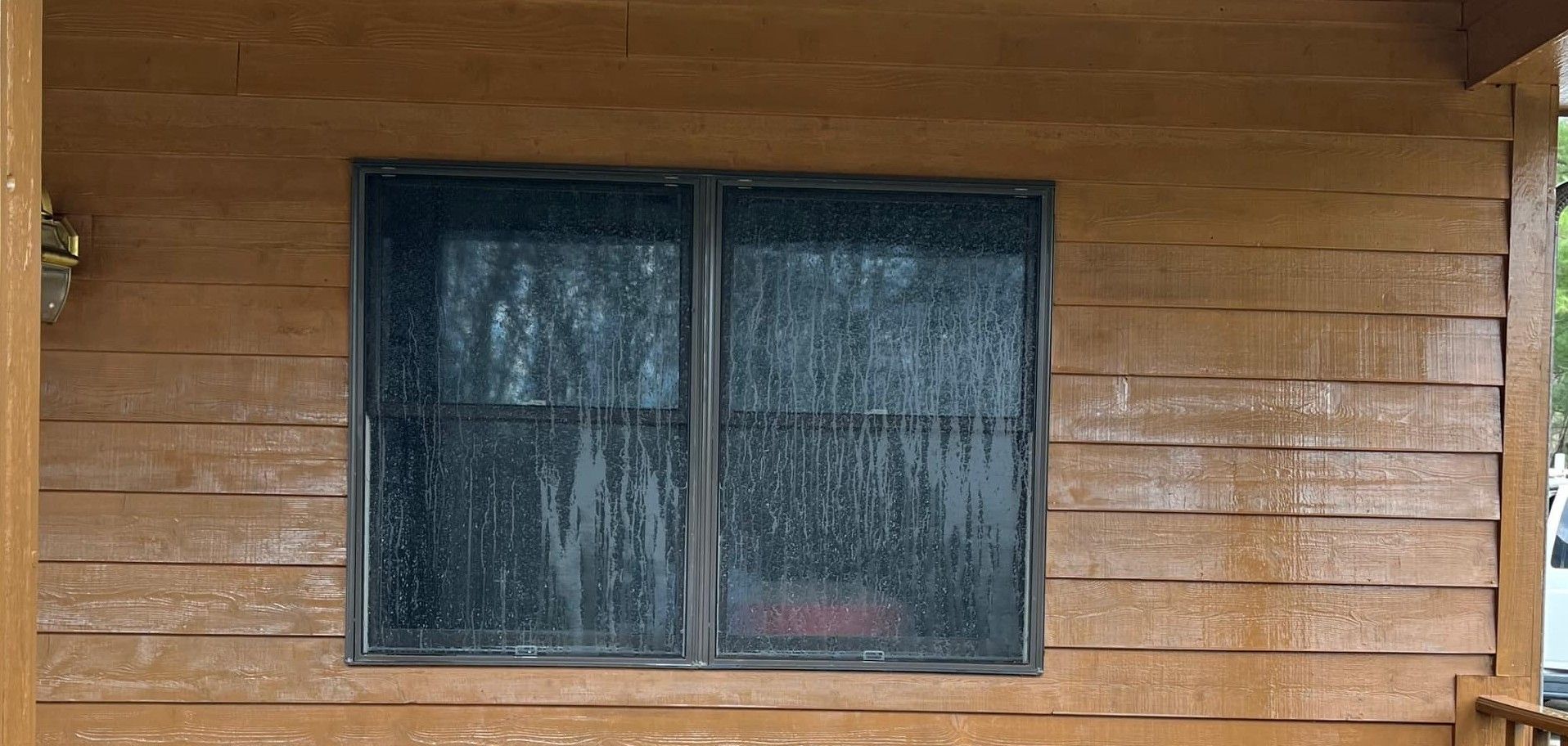 A wooden house with a window on the side of it.