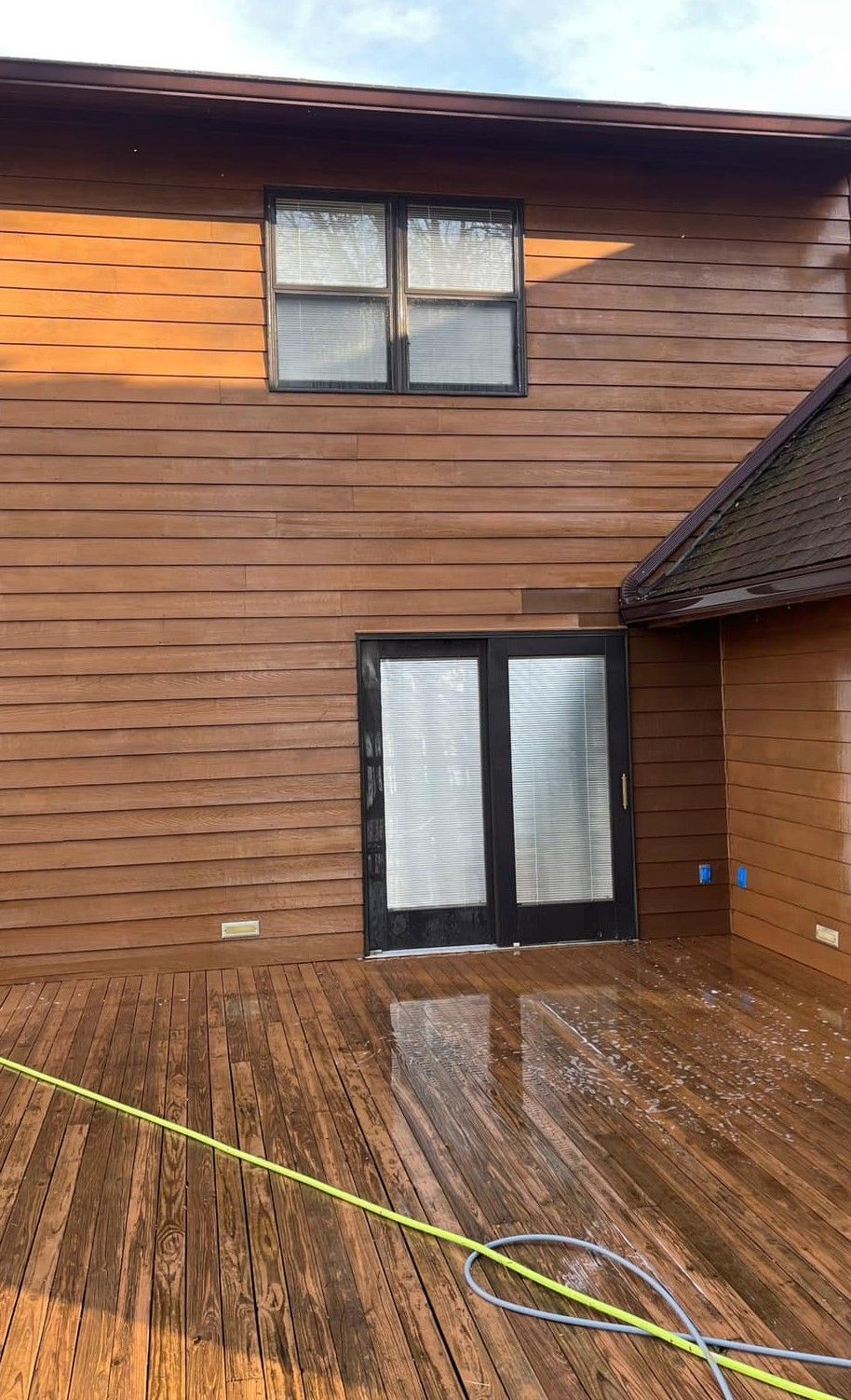 A house with a wooden deck and a sliding glass door.