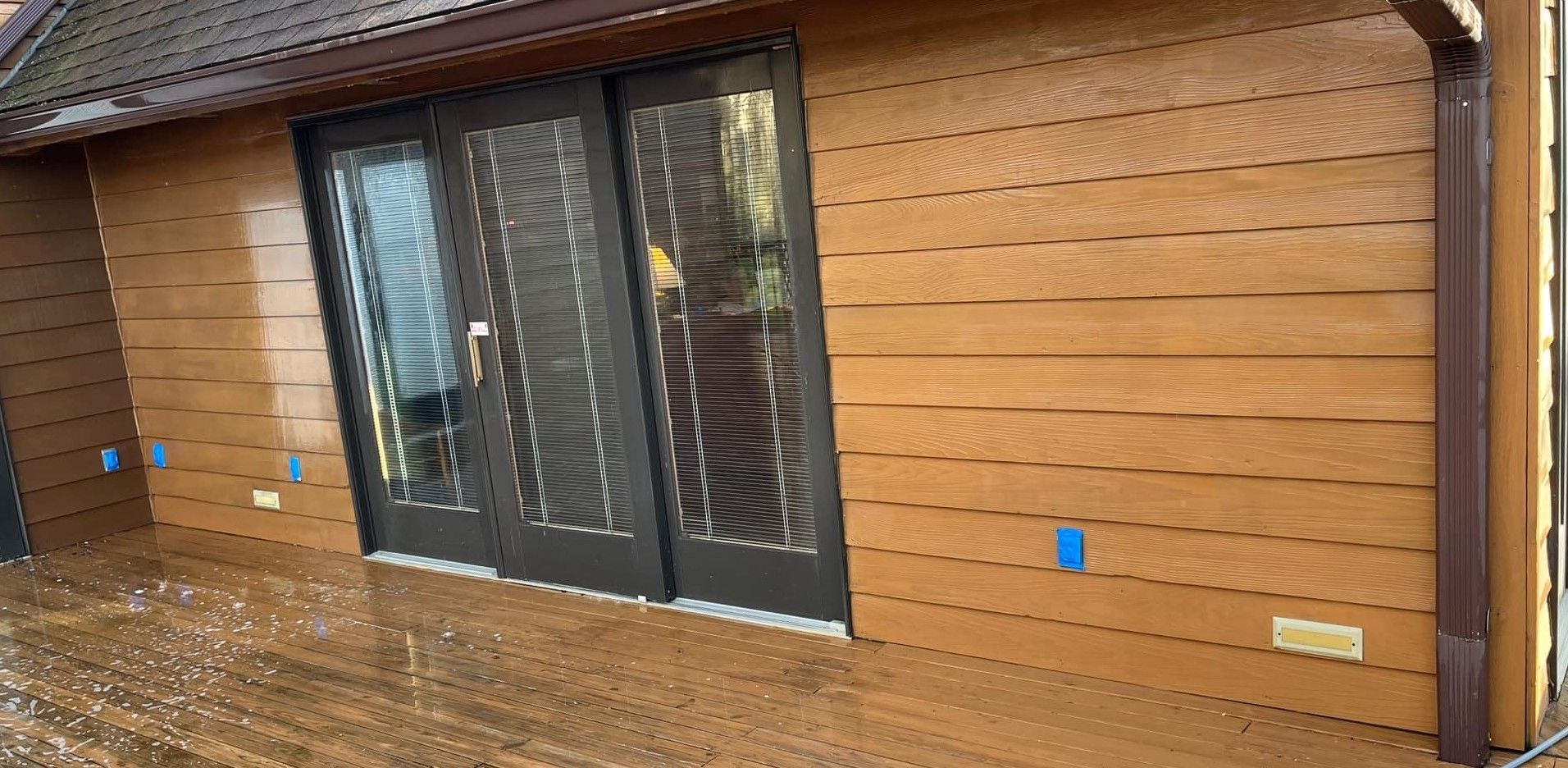 A house with a wooden siding and sliding glass doors.