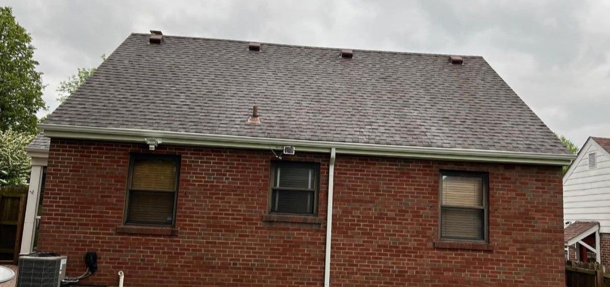A brick house with a roof that is covered in shingles.