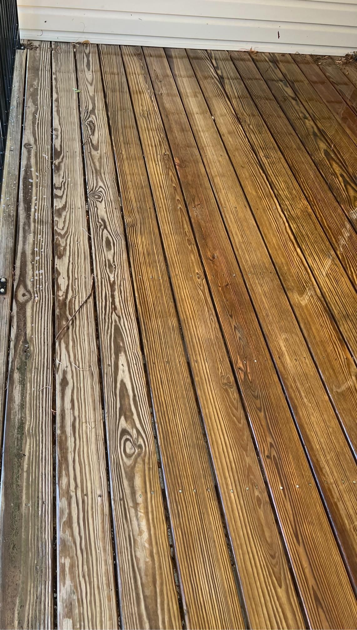 Weathered wooden deck boards with a white wall at the top edge