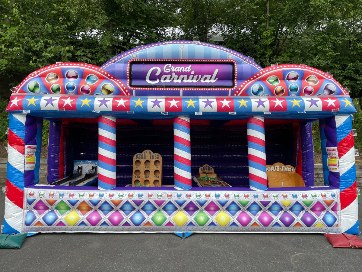 An inflatable Grand Carnival game stall with colorful stripes, star patterns, and three game booths for players.