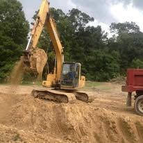 An aerial view of a bulldozer driving through a dirt field.