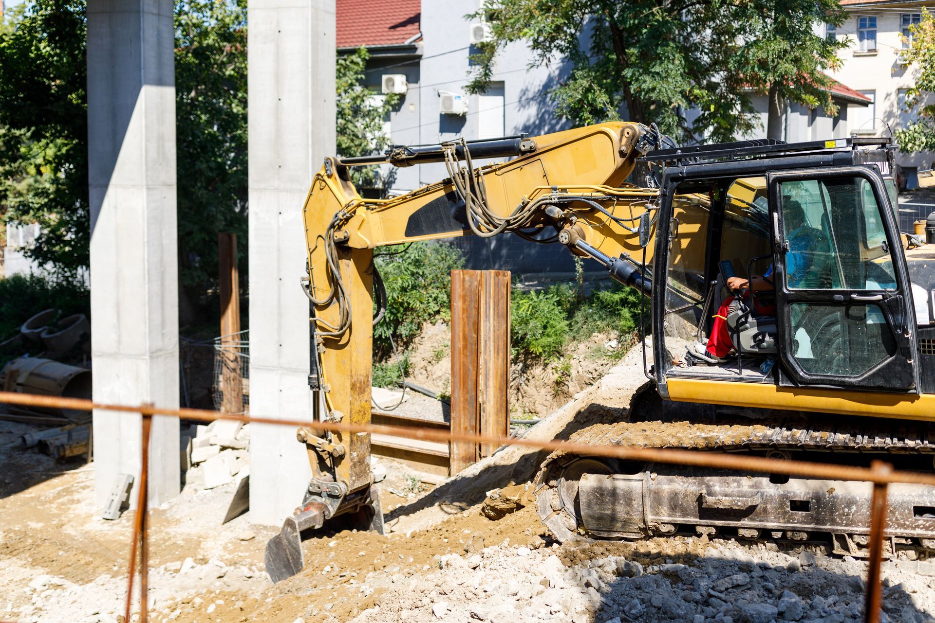 A yellow excavator is working on a construction site.