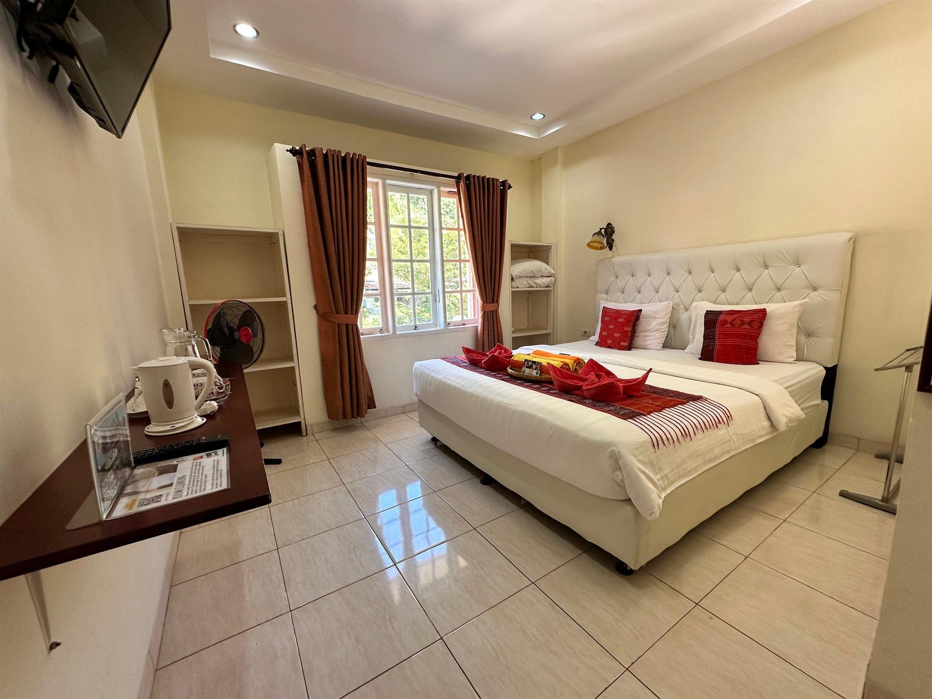 A bedroom with a bed , chair , desk and window.