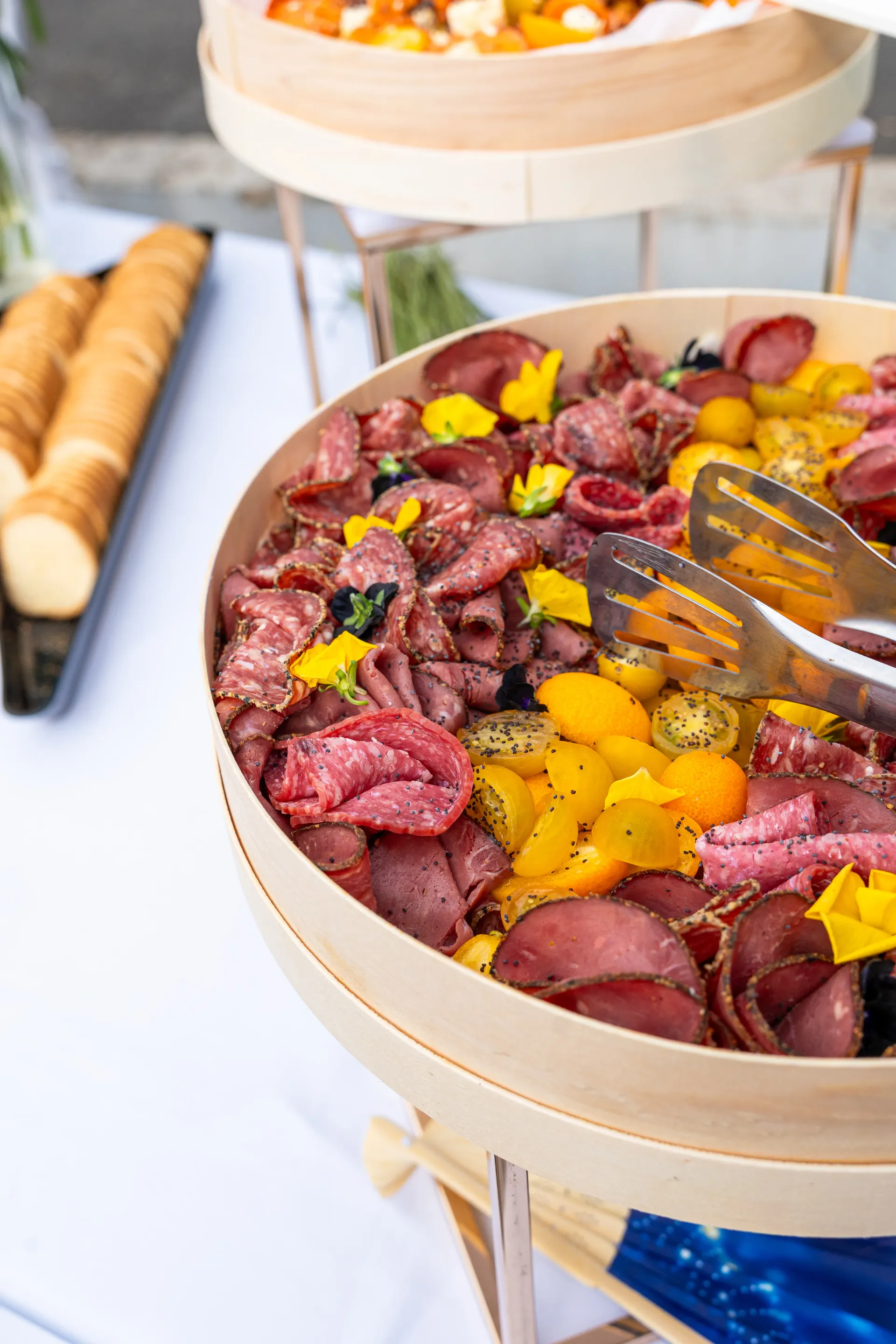 Des bols de fruits colorés coupés en tranches, garnis de pétales jaunes, sur une table de buffet