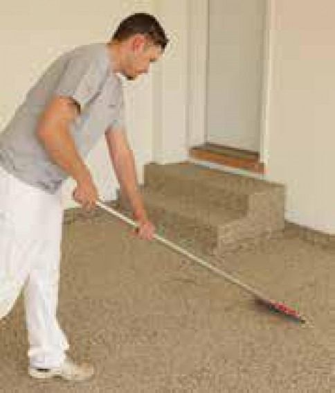 A man is sweeping the floor with a broom in a room.