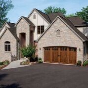A large brick house with a large wooden garage door.