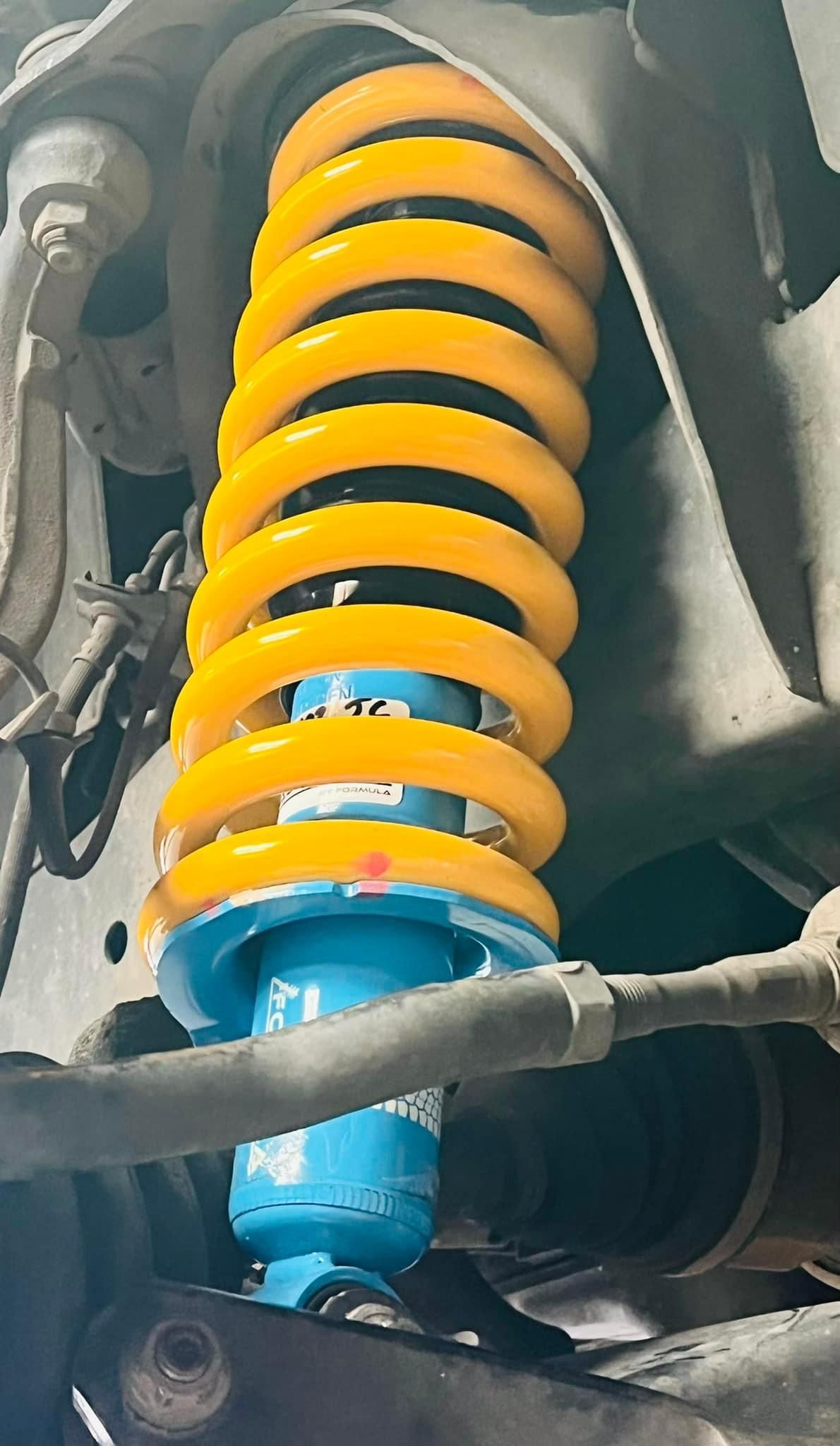 Close Up Of A Yellow And Blue Shock Absorber Of A Car — Shock Absorbers in Wollongong, NSW