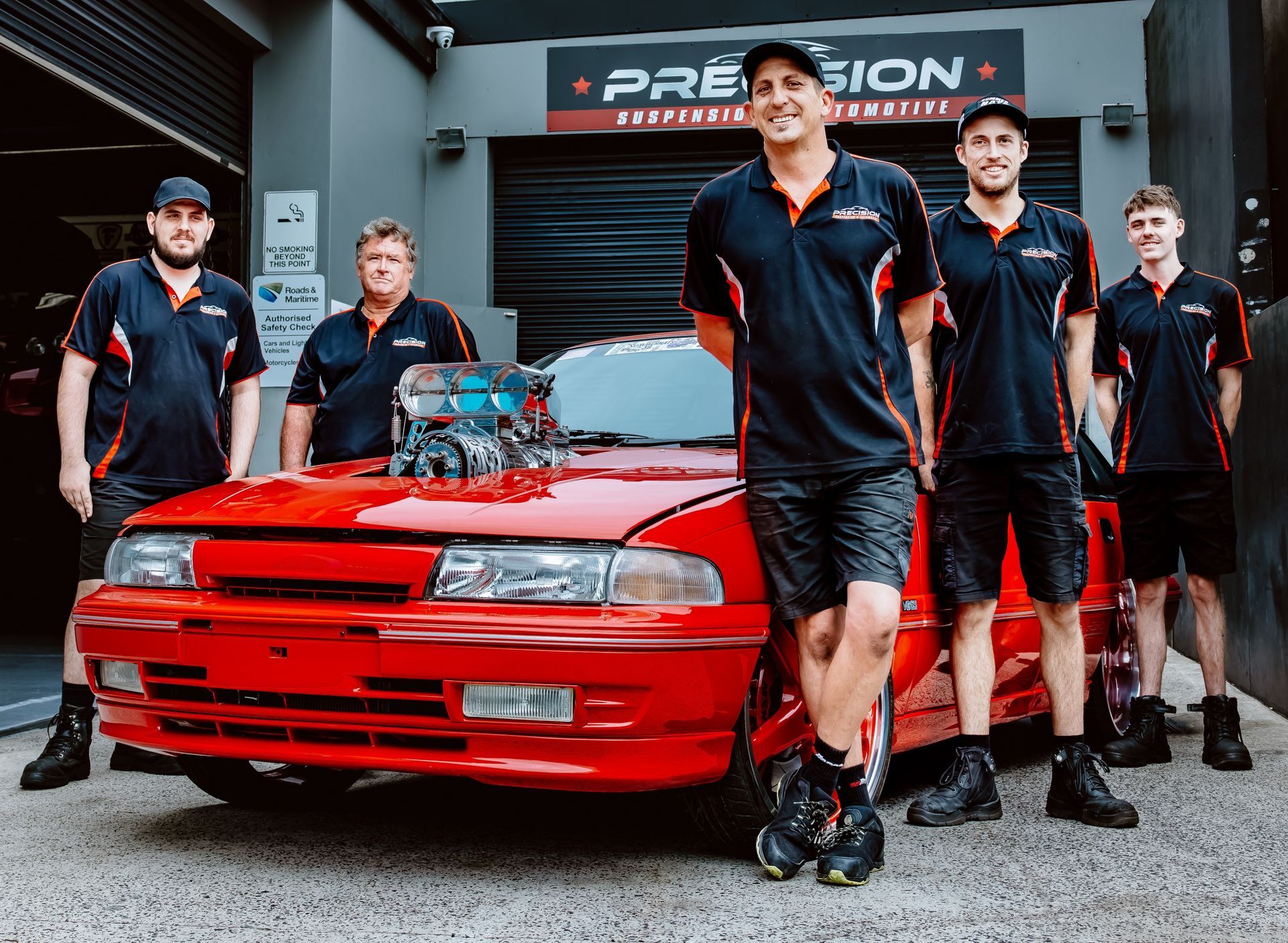 A Red Car Is On A Lift In The Garage — Mechanic in Wollongong, NSW