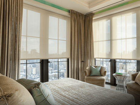 A bedroom with a bed , chair , table and lots of windows.