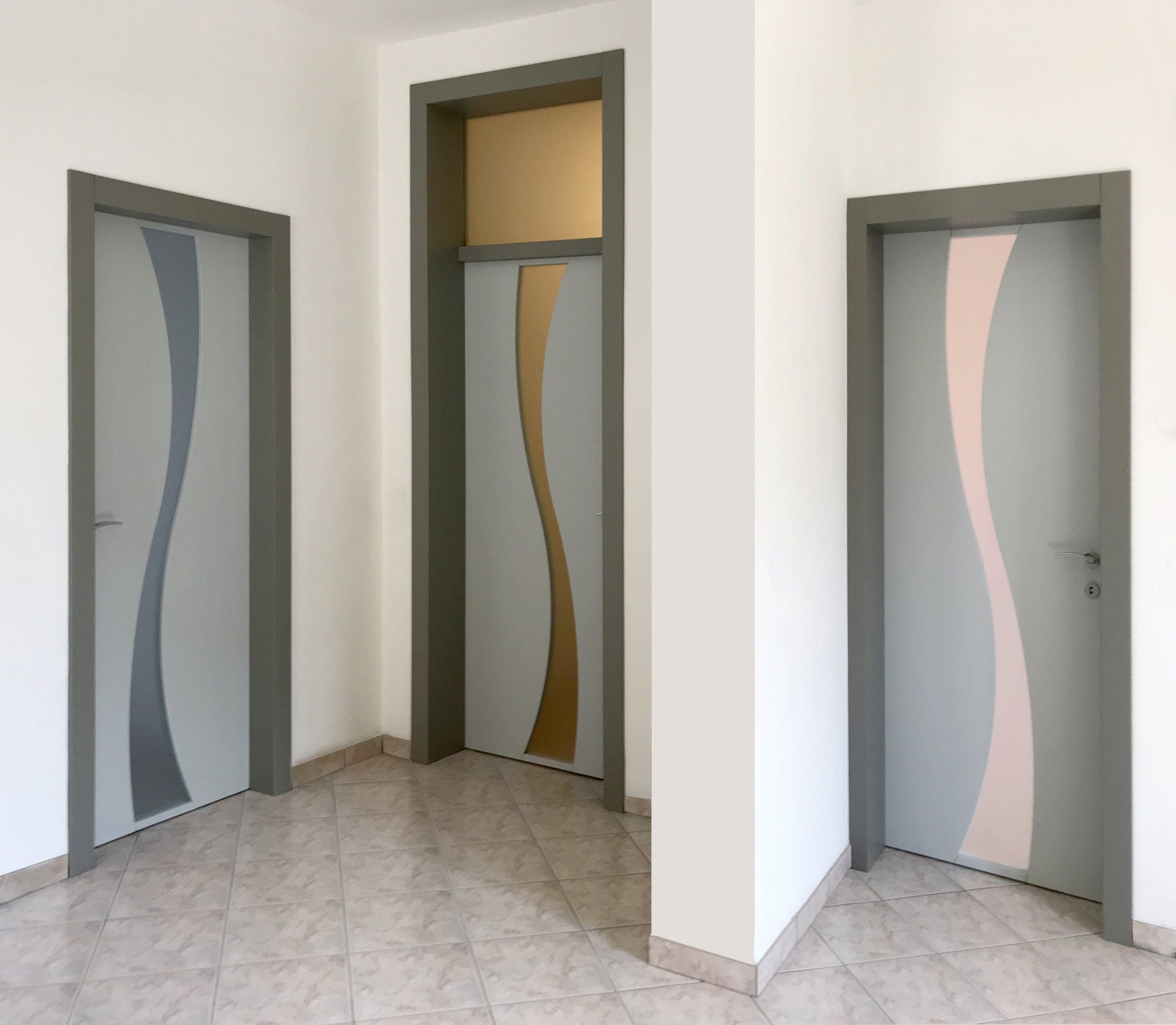 Tre porte grigie con decorazioni verticali a forma di onda nei toni del blu scuro, dell'oro e del rosa, incorniciate in grigio scuro, in una stanza bianca.