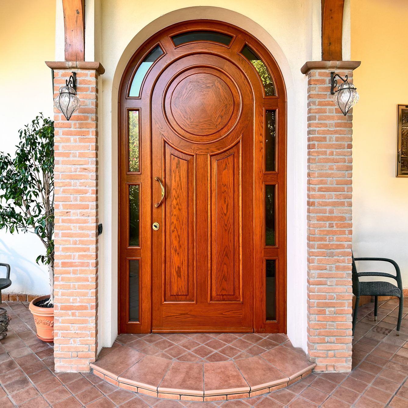 Una porta d'ingresso ad arco, rivestita in legno e con pannelli laterali in vetro