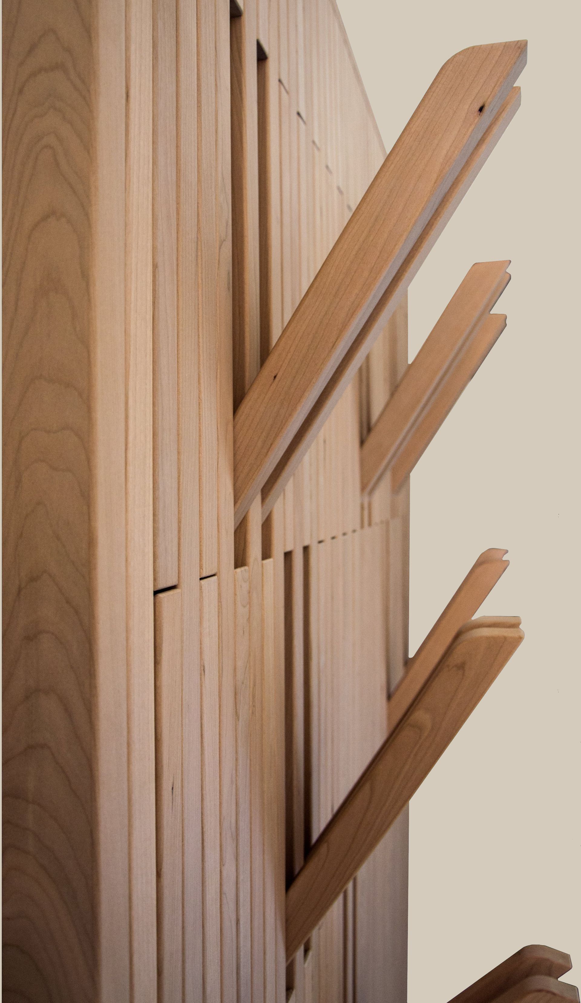 Un appendiabiti da parete in legno dotato di lamelle regolabili e retrattili che si aprono per fungere da ganci.