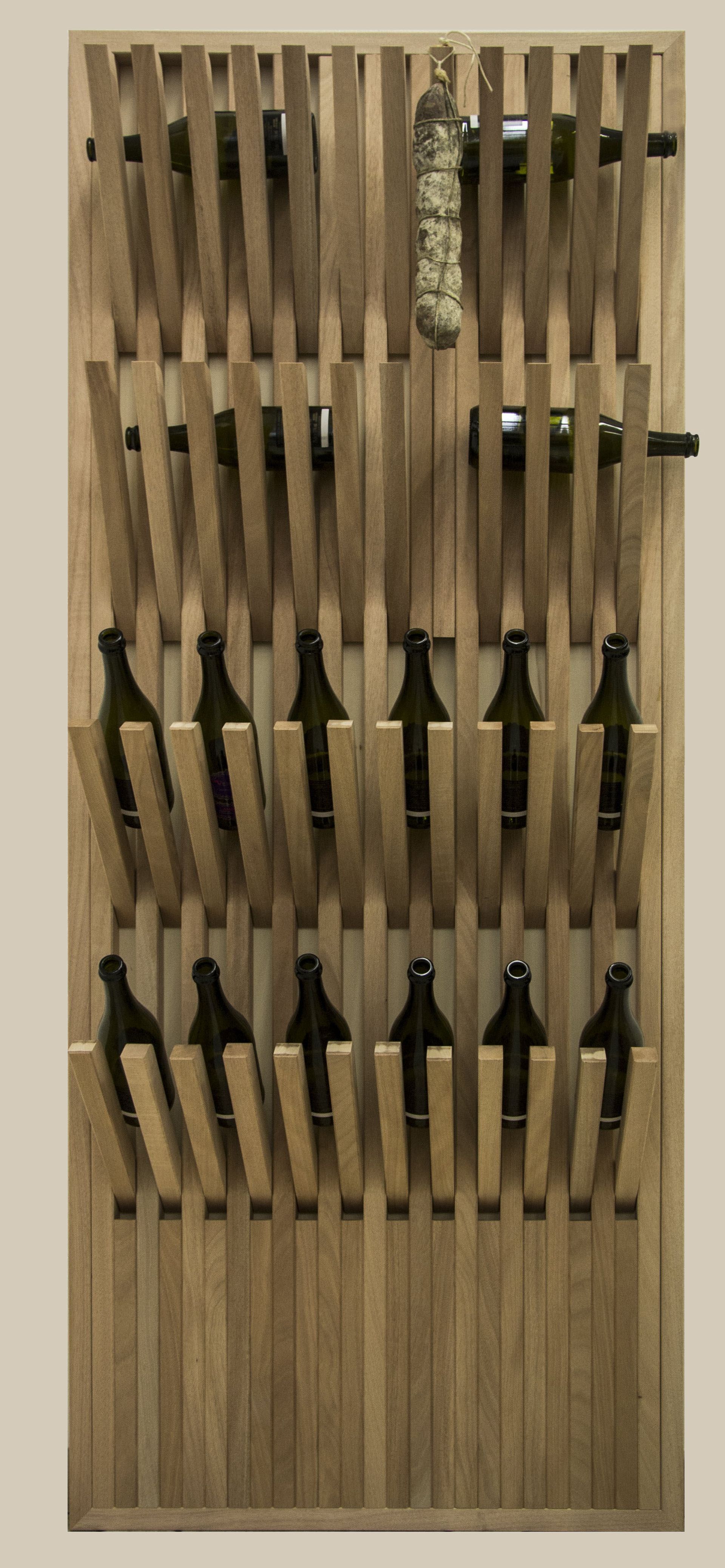 Una scaffalatura verticale in legno a muro espone due bottiglie di vino nella parte superiore, una salsiccia appesa e due file di coltelli in basso.
