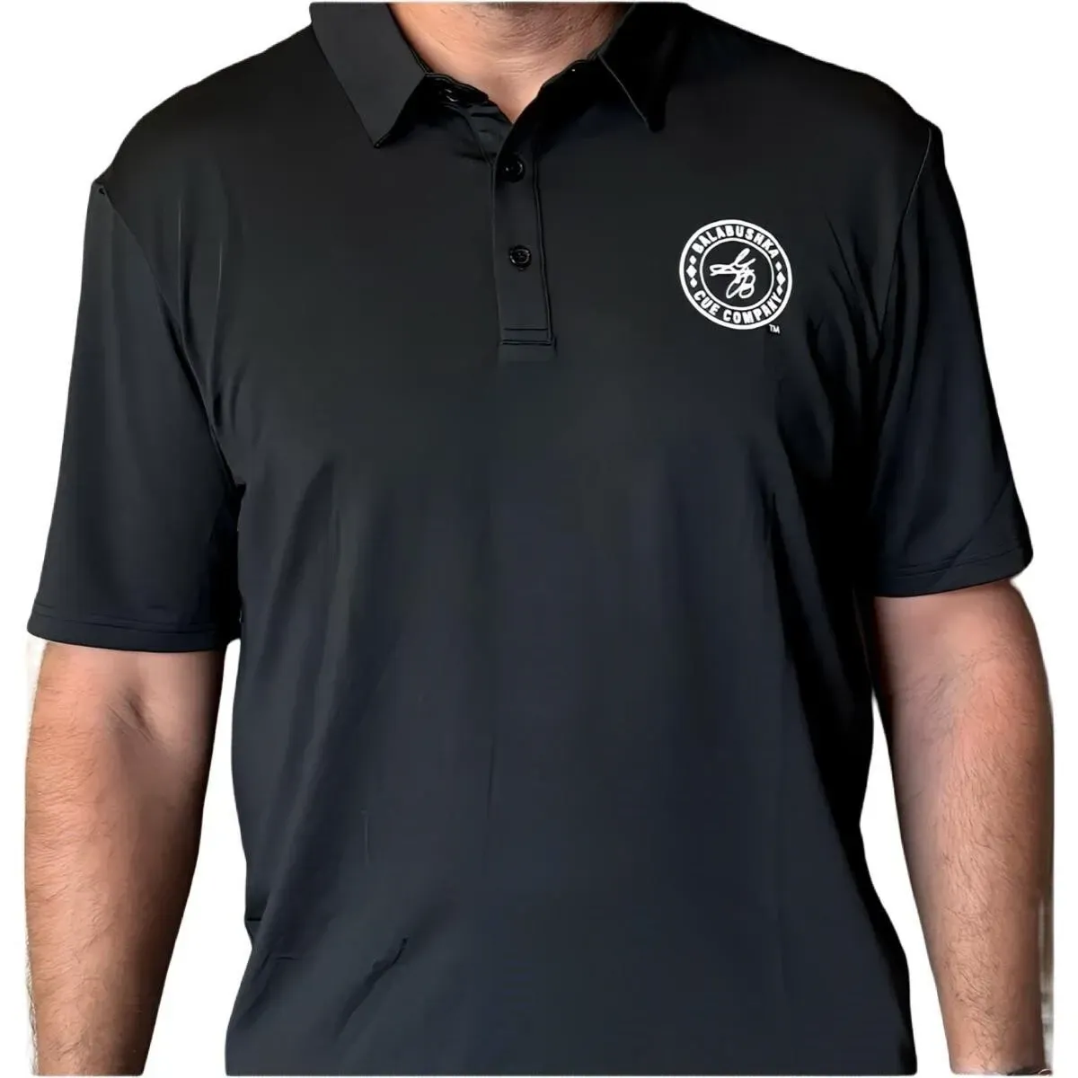 Black polo shirt with a white circular logo on the chest, worn by a person against a plain background