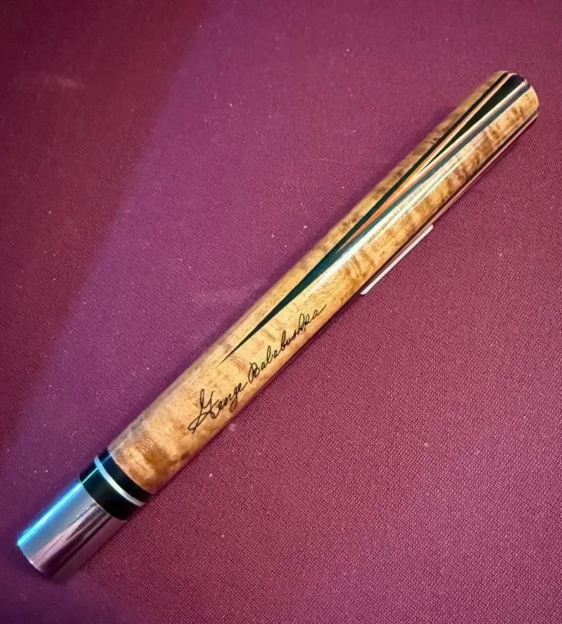 Wooden pen with black accents on a purple fabric background