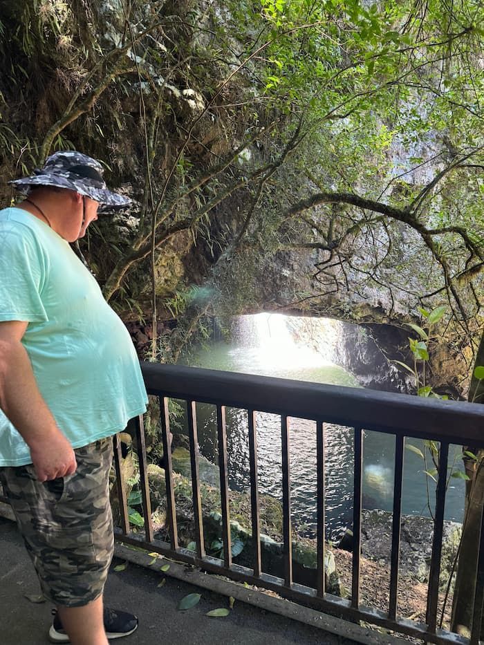 A Man is Standing on a Bridge Overlooking a Waterfall — Mentally Hooked in Helensvale, QLD