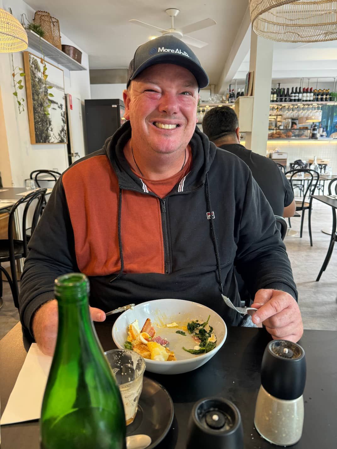 A Man is Sitting at a Table With a Bowl of Food and a Bottle of Water — Mentally Hooked in Helensvale, QLD