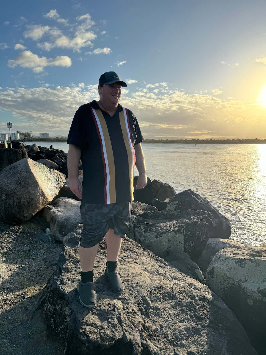 A Man is Standing on a Rock Near the Water — Mentally Hooked in Helensvale, QLD