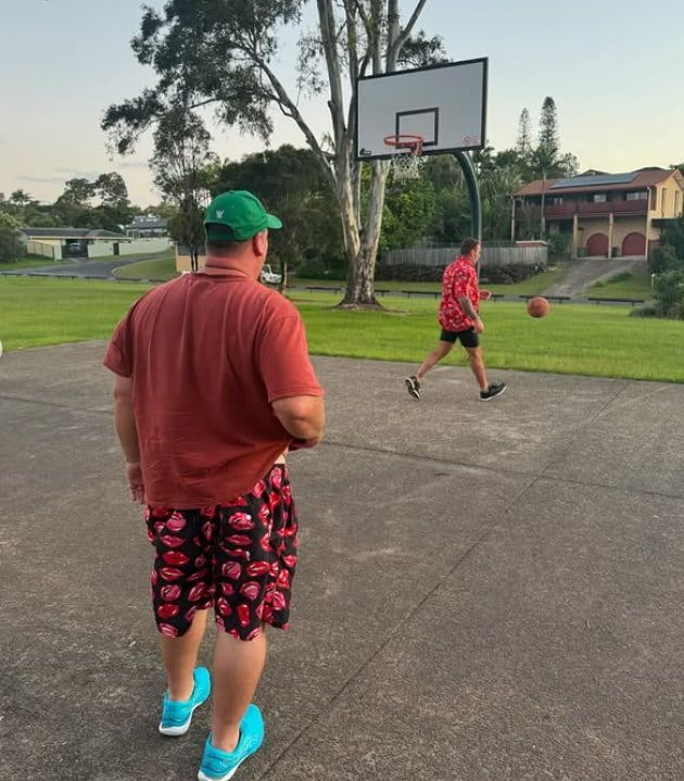 A Man in a Red Shirt is Watching Another Man Play Basketball — Mentally Hooked in Helensvale, QLD