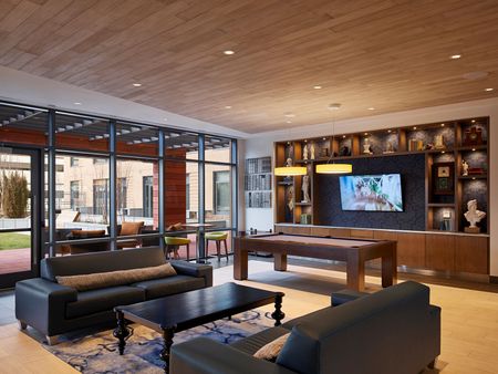 A community lounge area with furniture and a pool table at Solaire 8250 Georgia in Silver Spring, MD.