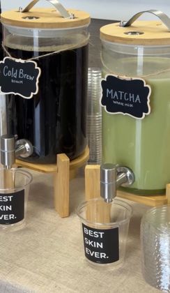 Two beverage dispensers labeled cold brew and matcha on a counter, each with a metal spout.