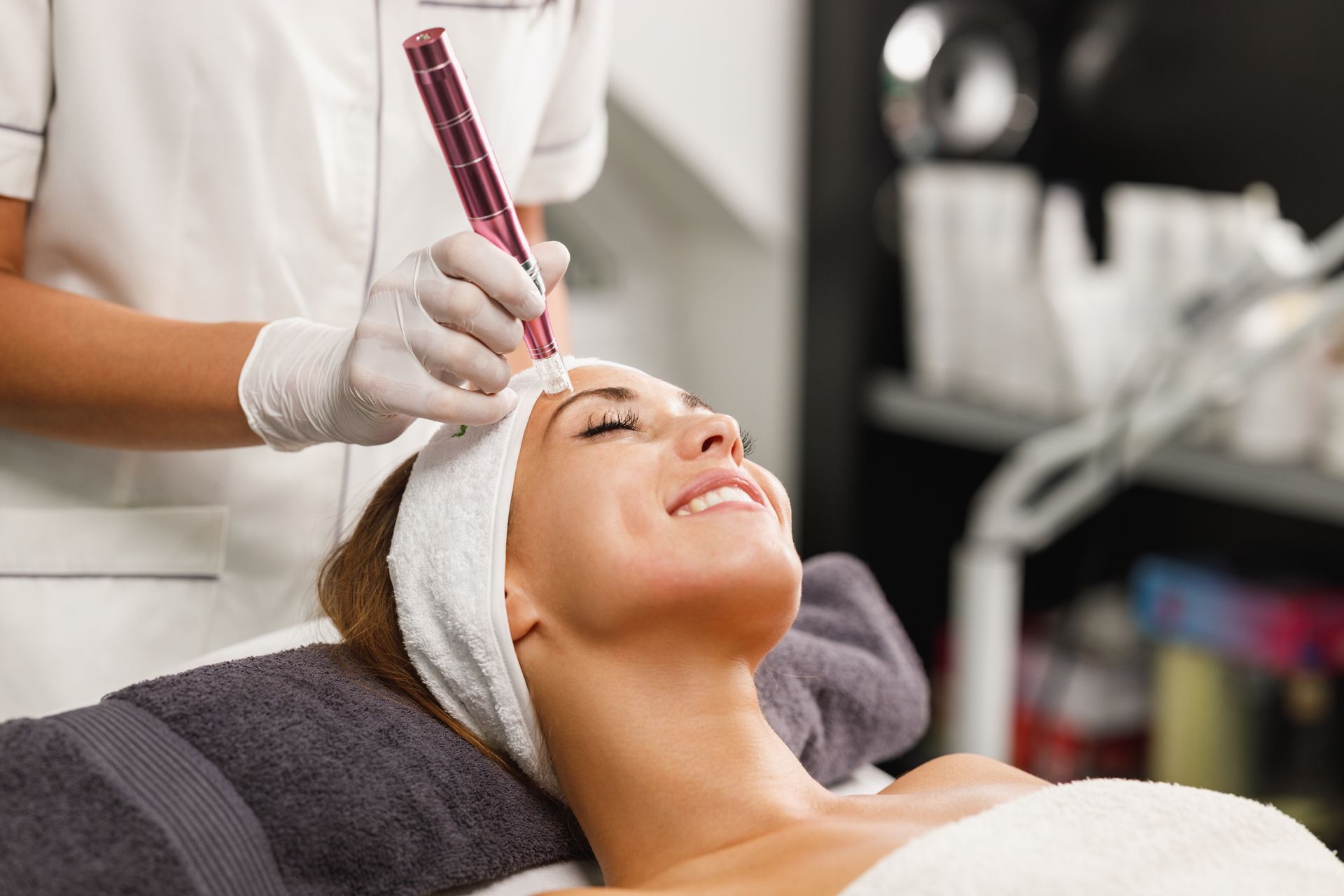 Facial treatment with gloved technician using a syringe on a woman’s forehead at a spa