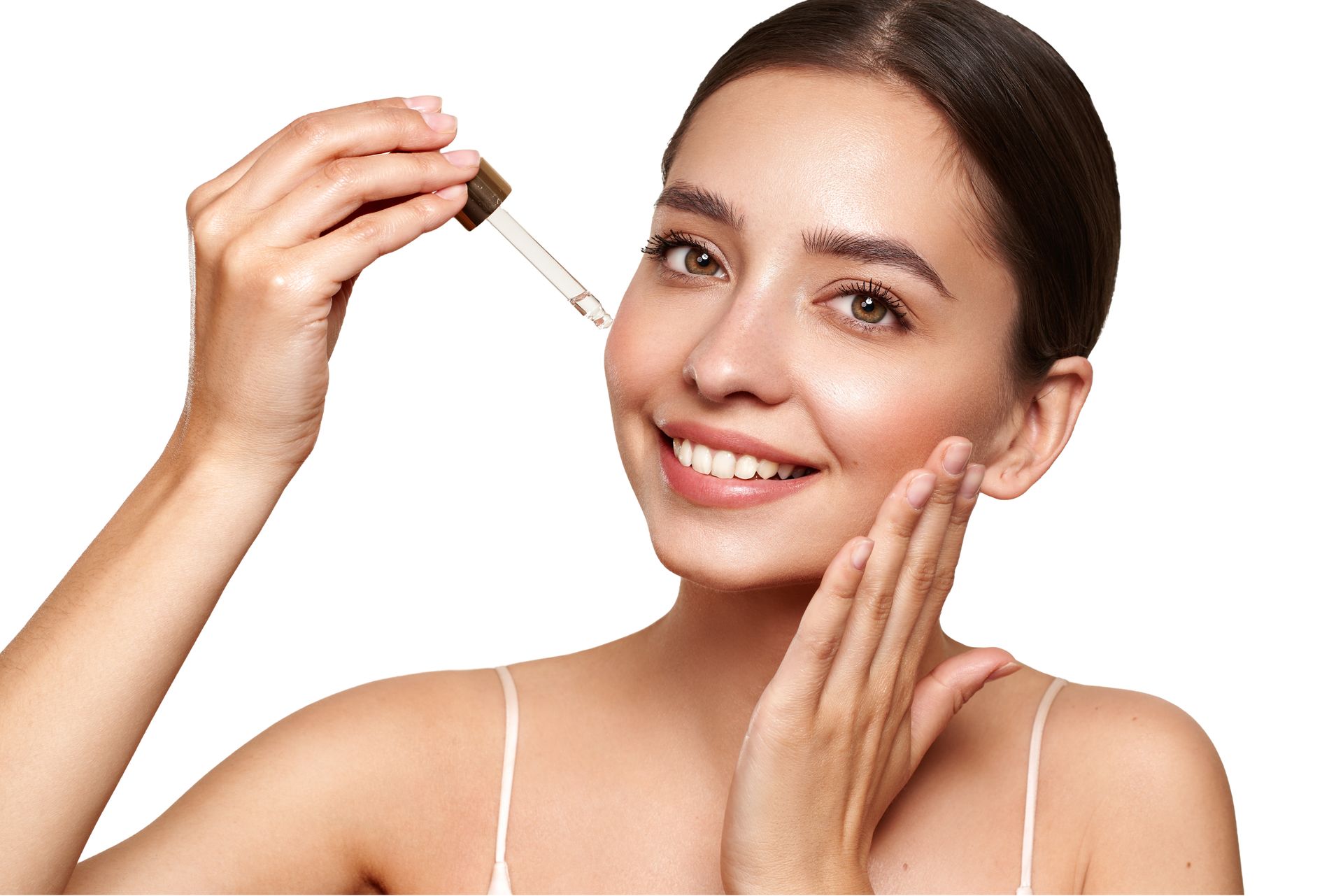 Woman applying facial serum with a dropper, smiling against a white background
