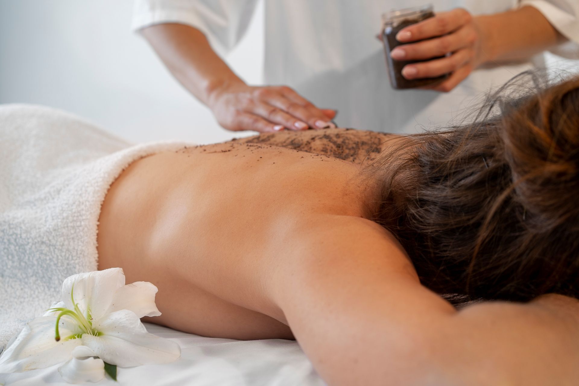 Person receiving a back massage with hot stones in a spa setting