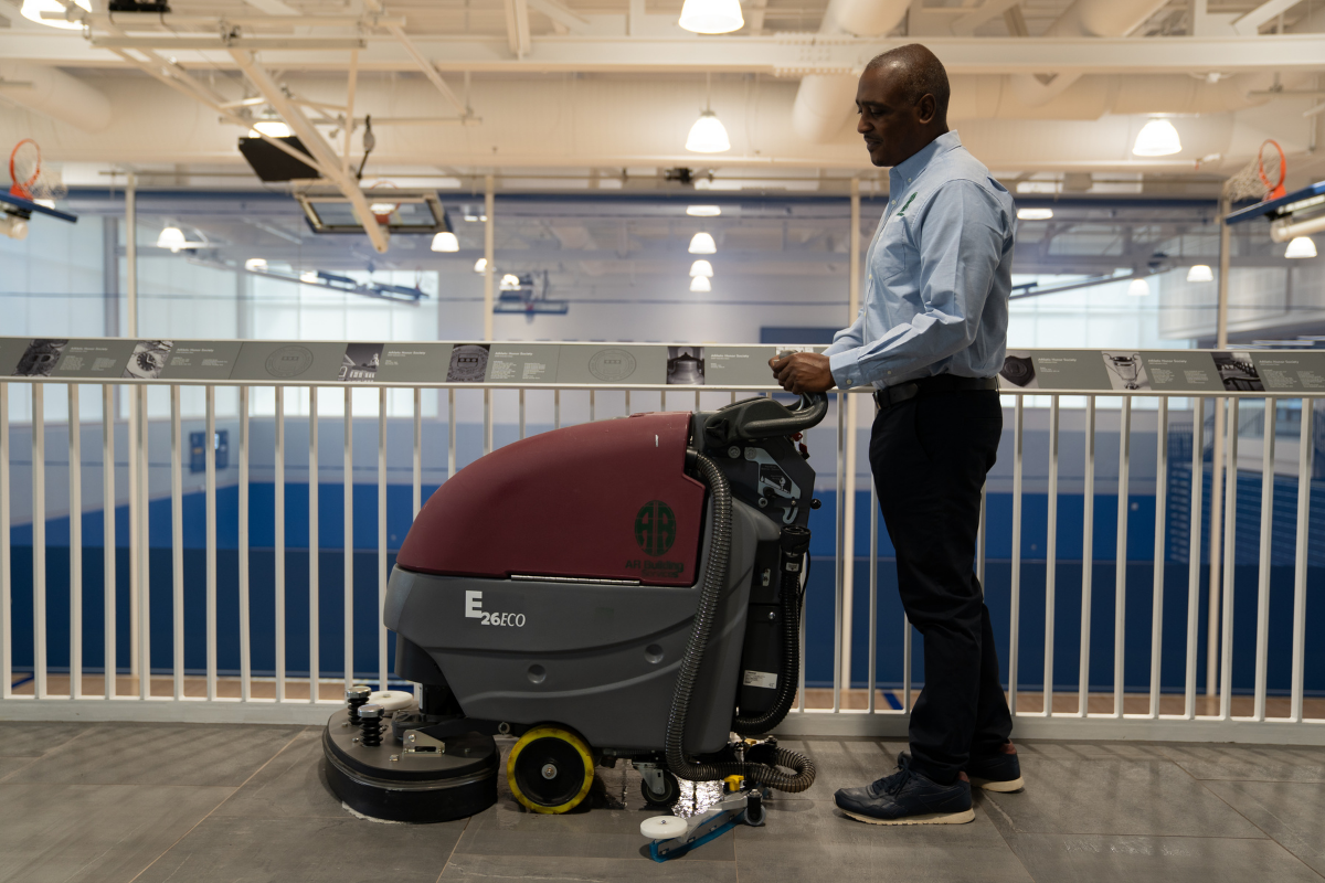 A person is using a machine to clean a granite floor.