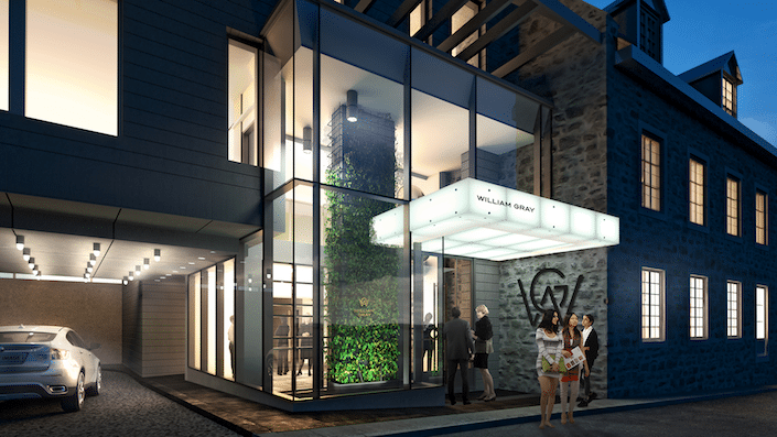Modern glass-fronted building entrance at night with people standing outside under bright lights