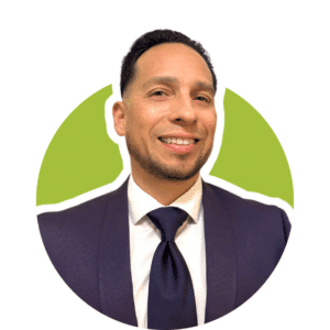 A smiling person wearing a dark blue suit and tie, set against a bright green circular background.