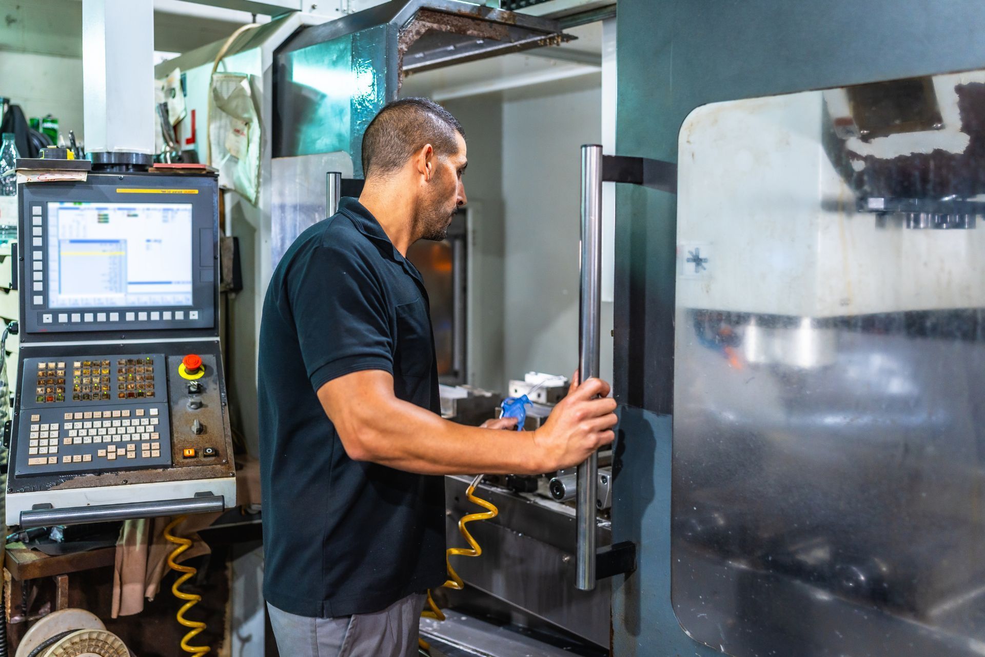 Technician operating a CNC machine in a factory workshop