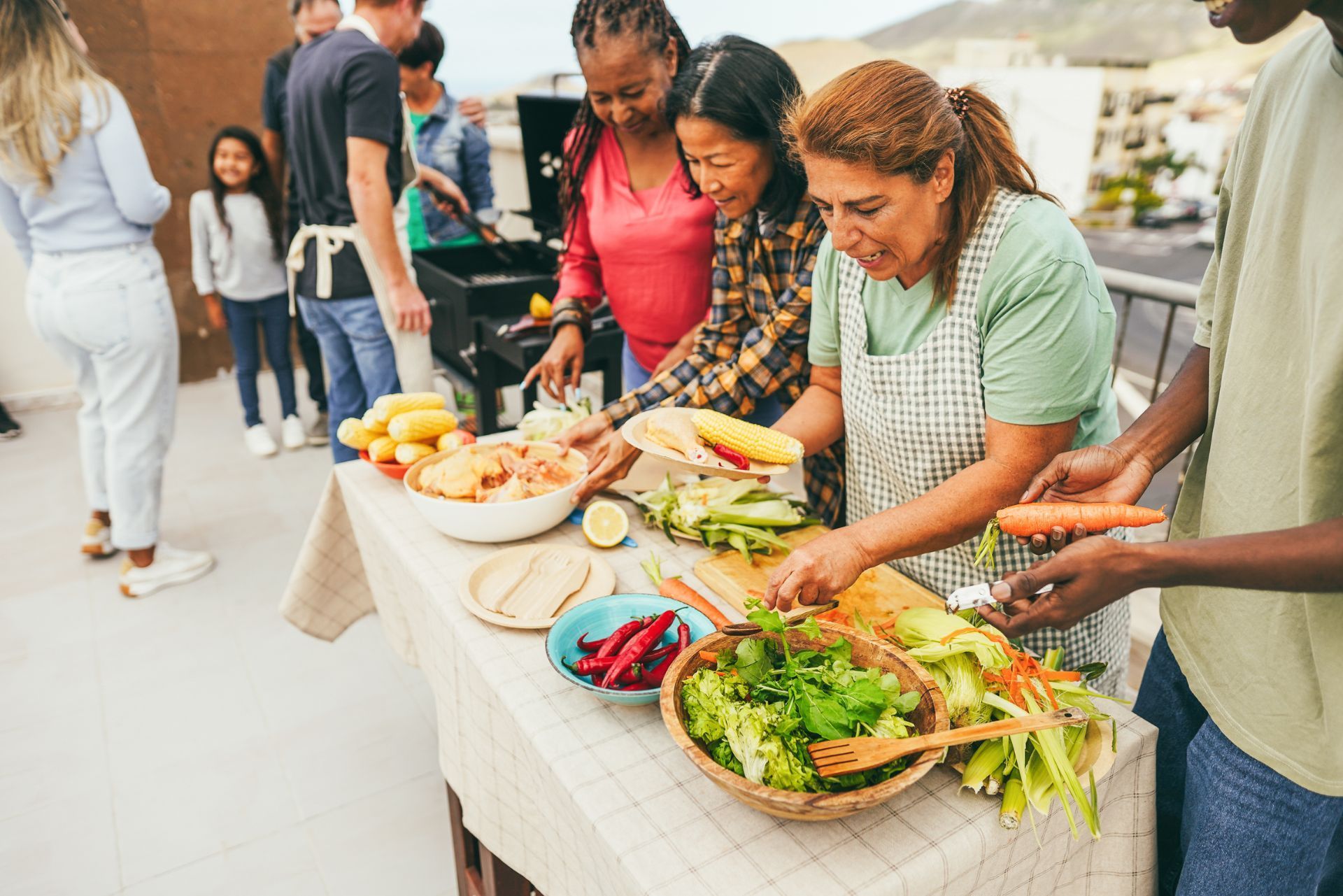 People serving and eating food at an outdoor community buffet table
