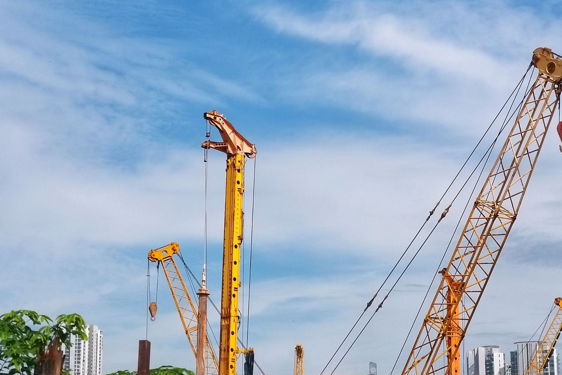 Construction cranes against a blue sky at a building site