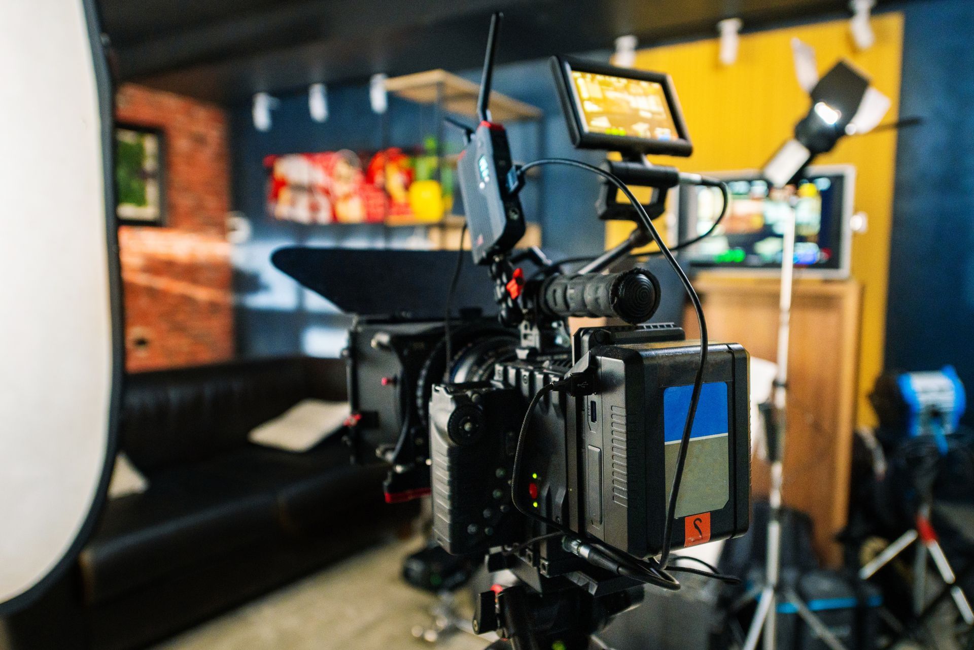 Professional video camera setup with monitor and lights in a studio-like room
