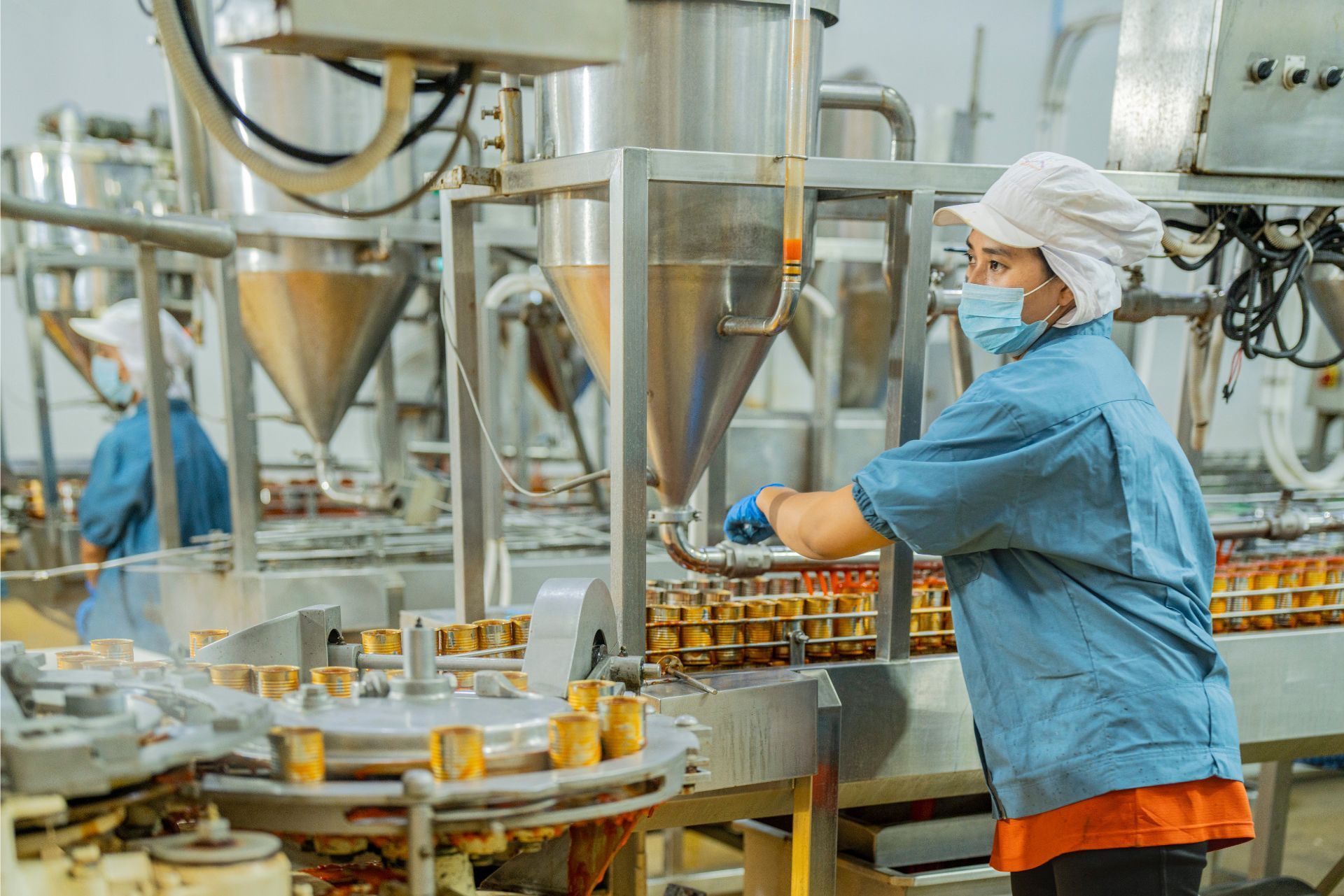 Worker in blue uniform operating machinery in a food processing factory