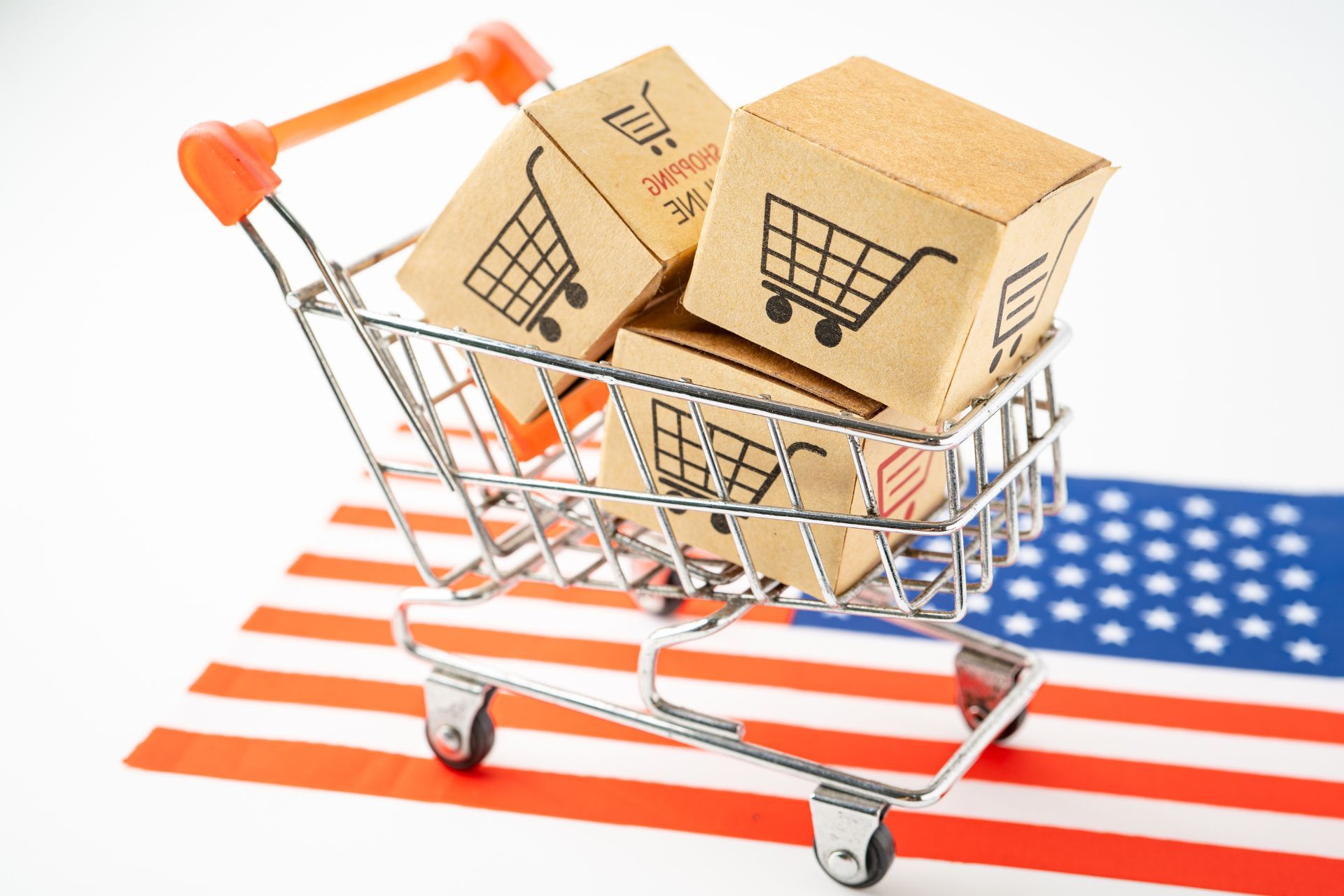 Shopping cart with two cardboard boxes on a U.S. flag background