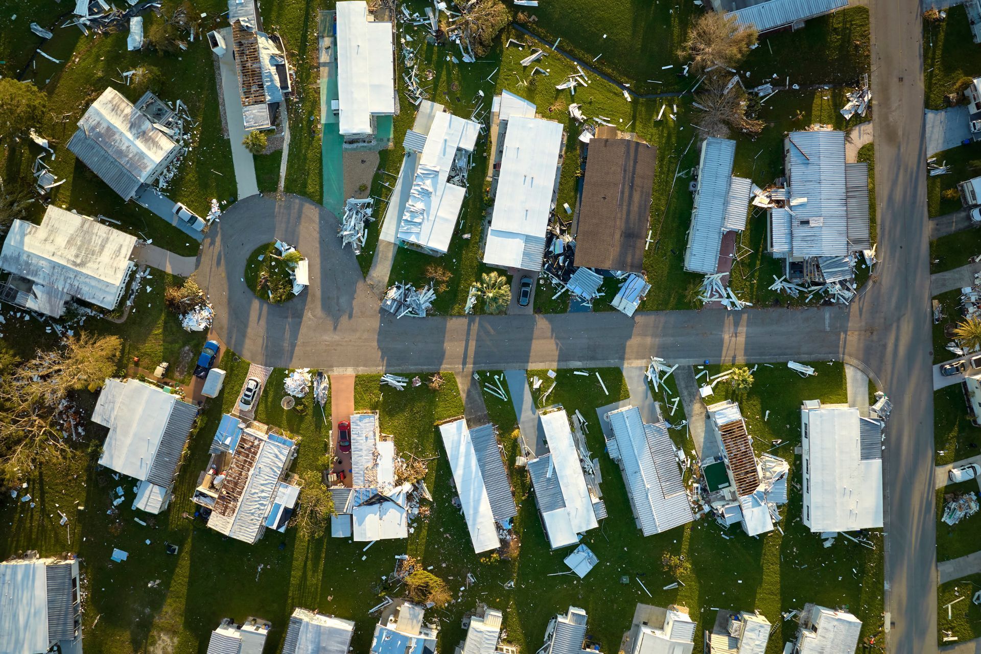 Aerial view of a trailer park with small mobile homes, trees, and roads.