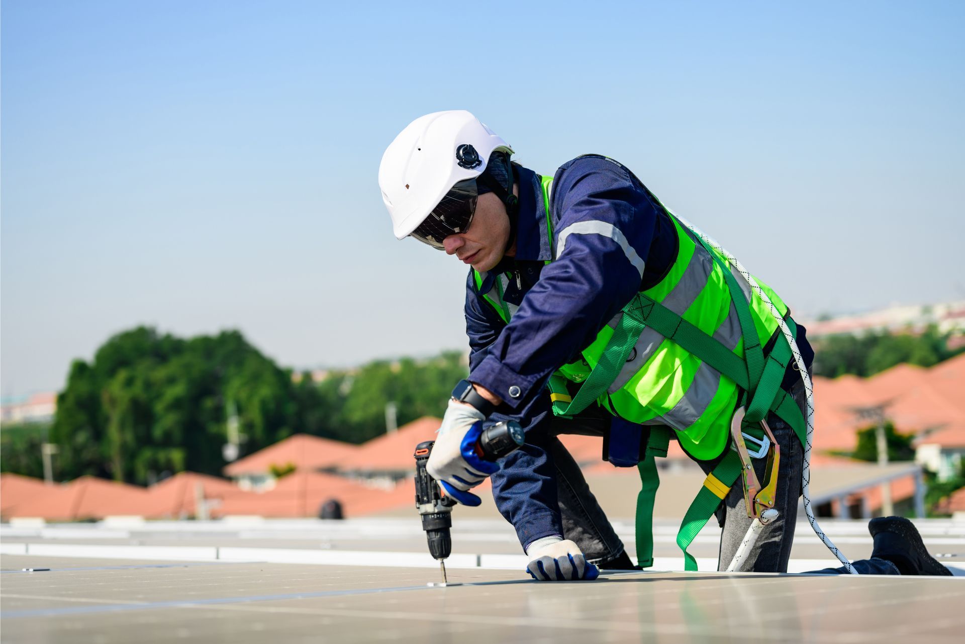 Construction worker in helmet and safety vest inspecting a rooftop