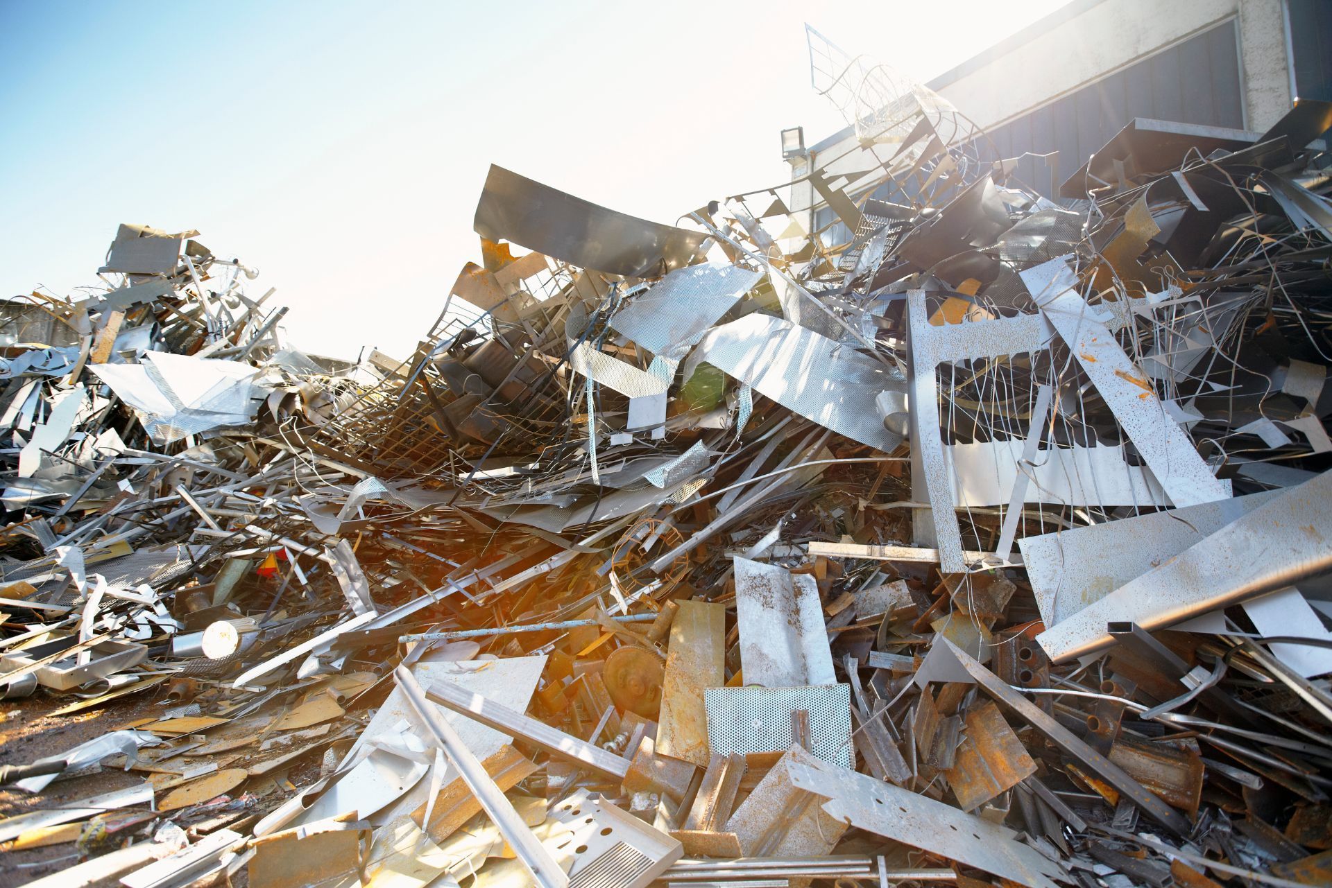 Piles of shattered metal and debris in bright sunlight, suggesting a collapsed industrial structure
