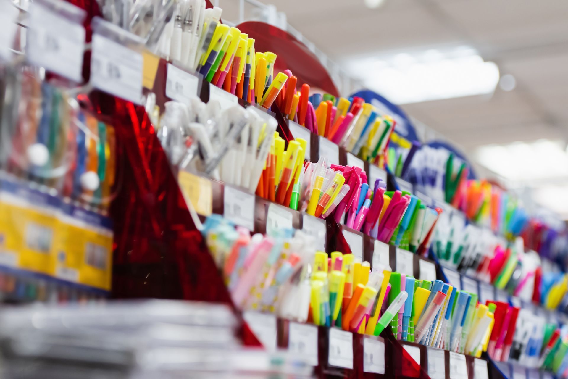 Colorful stationery items arranged on store shelves in a blurred retail aisle